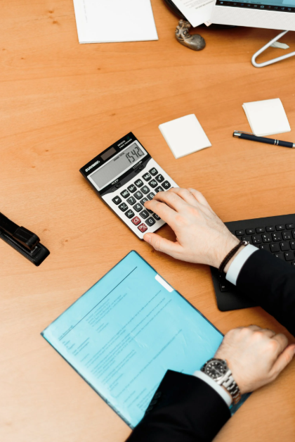 retenções fiscais: imagem de uma pessoa fazendo contas em sua mesa de trabalho