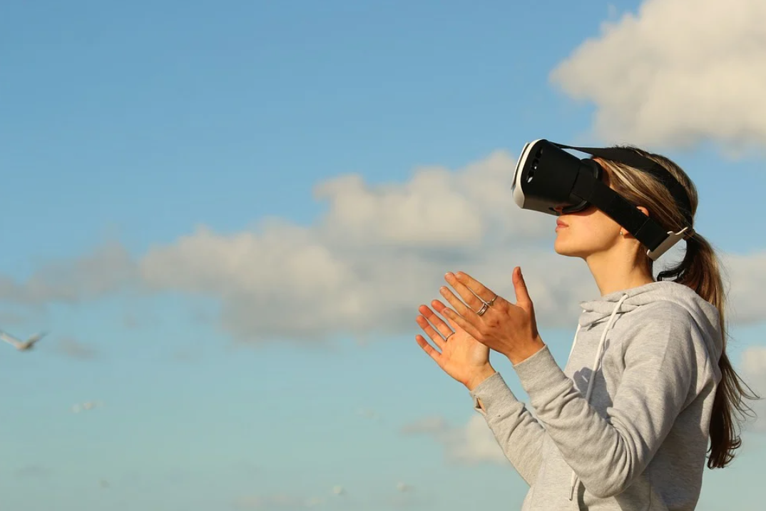 pós-obra: imagem mostra uma mulher com as mãos para a cima, usando um óculos de realidade virtual