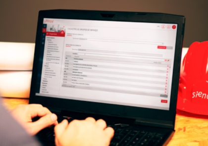 sistema de gestão para obras: imagem de um notebook com o dashboard do Sienge aberto e as mãos de uma pessoa sobre o teclado